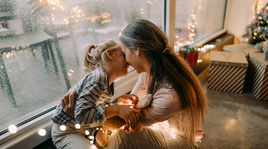 Mutter und Kind lachen glücklich an Weihnachten