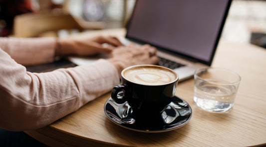 Kaffee und Laptop auf Holztisch im Café