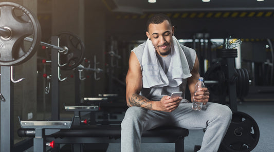 Mann ruht sich nach dem Training im Gym aus