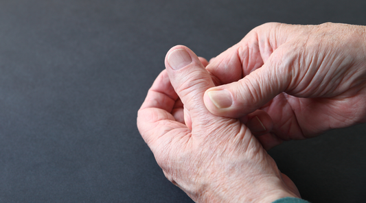 Ältere Person hält schmerzendes Daumengelenk bei Rhizarthrose – typische Anzeichen für Arthrose im Daumensattelgelenk mit Schmerzen und eingeschränkter Greiffunktion