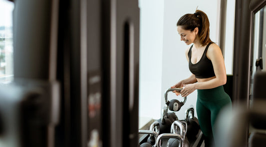 Frau im Fitnessstudio hebt eine Kettlebell beim Krafttraining