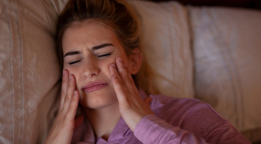 Frau mit Kieferschmerzen im Bett