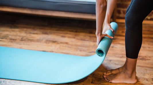Yogamatte ausrollen für Yoga- oder Fitness-Training
