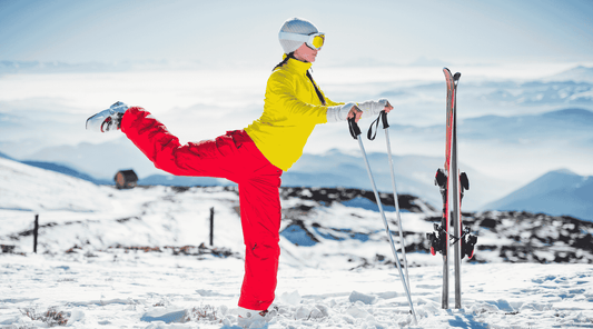 Eine Frau in einer winterlichen Berglandschaft dehnt sich nach dem Skifahren. 