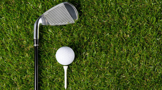 Golfball und Schläger auf Rasen Nahaufnahme