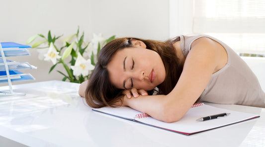 Frau schläft erschöpft am Schreibtisch einFrau schläft erschöpft am Schreibtisch ein Frühjahrsmüdigkeit