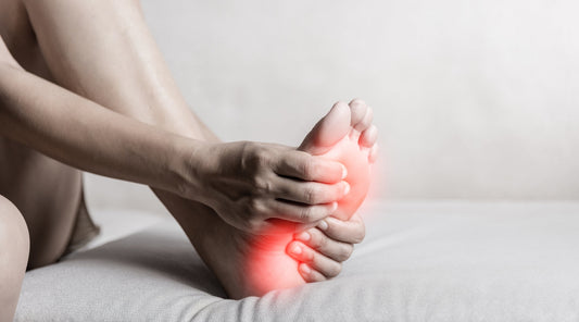 Person greift nach Fuß Schmerzen Massage