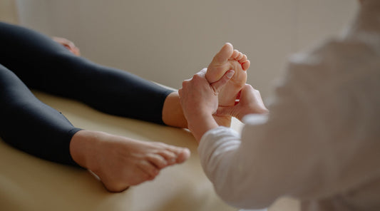 Physiotherapeut behandelt schmerzenden Fuß – professionelle Fußmassage bei Fußbeschwerden