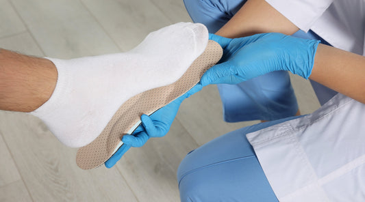 Orthopäde passt individuelle Einlage an Fuß mit Socke an – Therapie bei Fußschmerzen oder Fehlstellungen