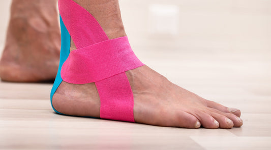 Fuß mit buntem Kinesio-Tape bei Schmerzen im Sprunggelenk – unterstützende Maßnahme in der Physiotherapie