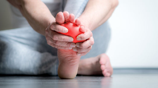 Person hält schmerzenden Fuß – typisches Symptom bei Fußschmerzen, Plantarfasziitis oder Überlastung
