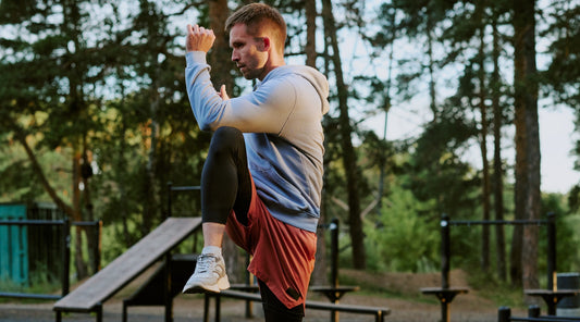Mann trainiert Beinmuskulatur im Outdoor-Fitnesspark