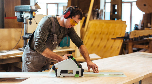 Handwerker schneidet Holz mit Kreissäge in Werkstatt
