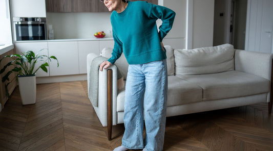Ältere Frau mit Rückenschmerzen Hexenschuss im Wohnzimmer