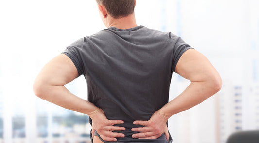 Mann hält sich mit Rückenschmerzen den unteren Rücken Hohlkreuz