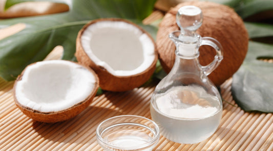 Frische Kokosnüsse und Kokosöl in einer Glasflasche