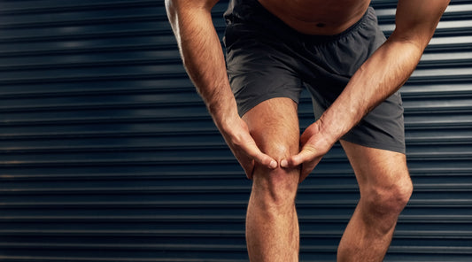 Sportler mit Knieschmerzen nach dem Training – mögliche Gelenküberlastung durch intensives Krafttraining