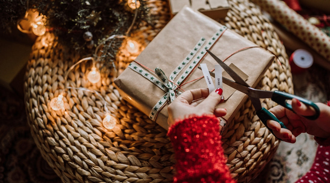 Geschenk mit Naturpapier und „Merry Xmas“-Anhänger wird dekoriert