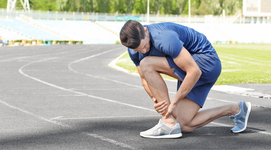 Jogger mit Fußschmerzen auf Laufbahn – Sportverletzung beim Laufen