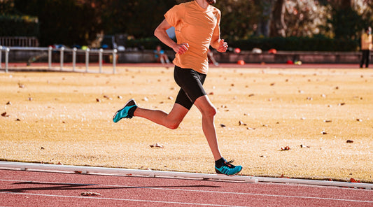 Mann beim Lauftraining auf der Tartanbahn mit effizienter Lauftechnik