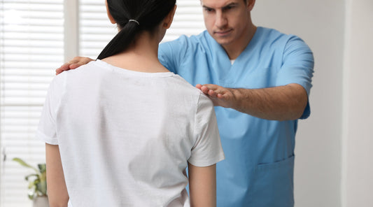 Arzt untersucht Skoliose einer Patientin in der Praxis