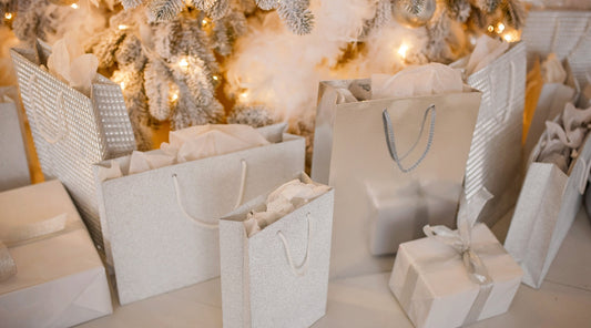 Elegante silberne Geschenkboxen unter festlich geschmücktem Baum