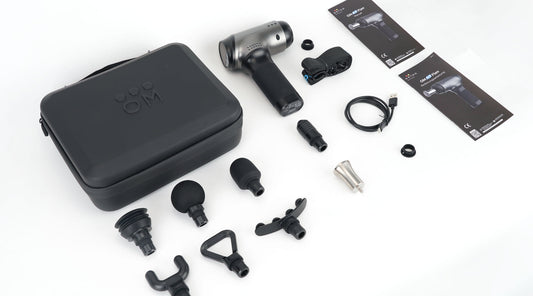 Massagepistole mit Verpackung und Aufsätzen ausgepackt