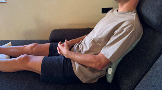 Mann mit Rückenmassagegerät auf dem Sofa