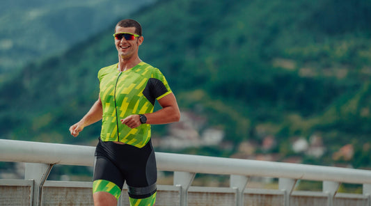 Sportler läuft im Triathlon-Outfit in Berglandschaft