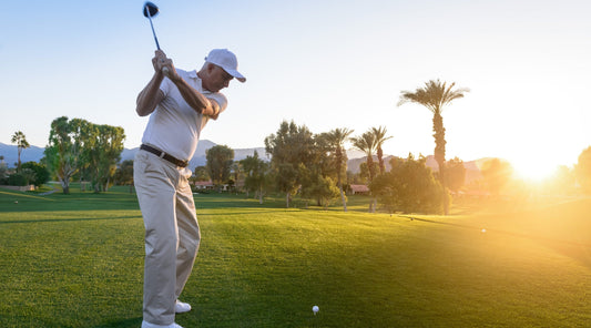 Golfspieler beim Abschlag im Sonnenlicht
