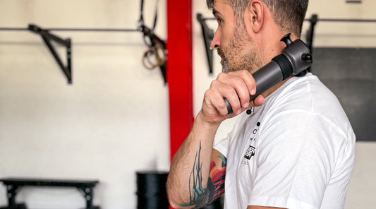 Mann hält Schallwellengerät zur Muskelentspannung