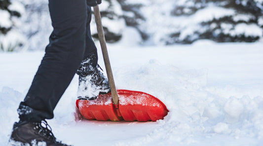 Schneeschippen mit roter Schneeschaufel