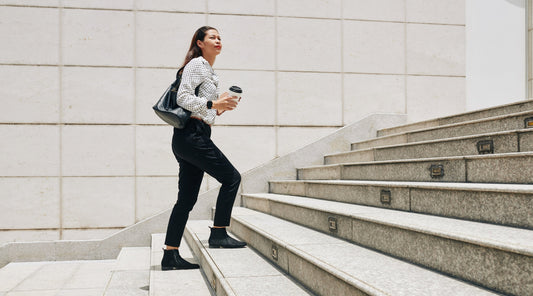 Geschäftsfrau steigt sportlich motiviert Treppen hinauf
