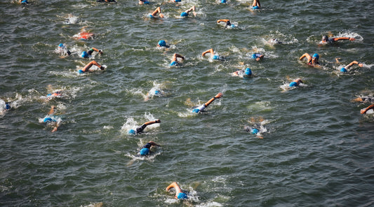 Triathleten schwimmen im offenen Gewässer Wettkampf