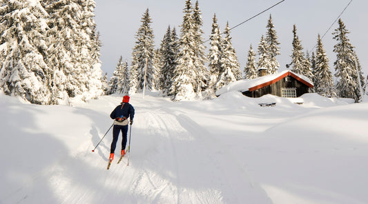 Langläufer auf verschneiter Strecke bei Berghütte