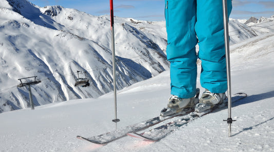 Skifahrer steht auf der Piste mit Blick auf die Berge