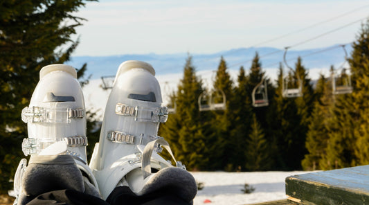 Orangene Skischuhe werden in Skibindung eingerastet