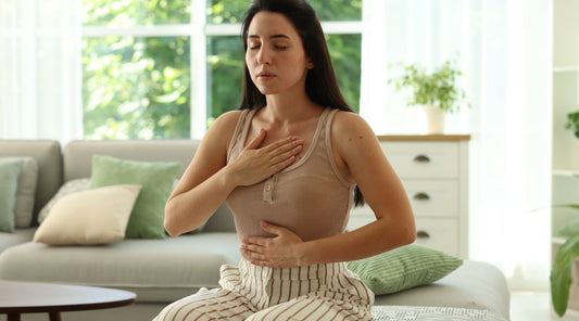 Frau macht Atemübung im Wohnzimmer Panickattacke