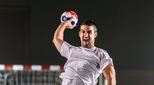 Handballspieler wirft kraftvoll aggressiv den Ball beim Spiel