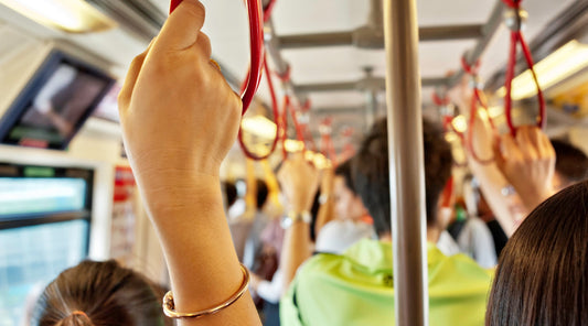 Menschen halten sich an Haltegriffen in überfüllter U-Bahn fest