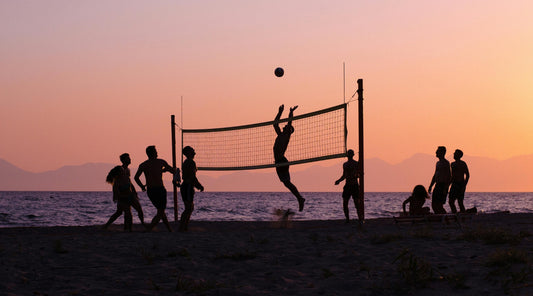 Freunde spielen Beachvolleyball bei Sonnenuntergang