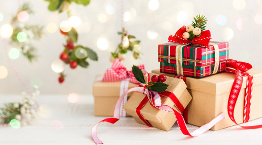 Bunte Weihnachtsgeschenke mit Karomuster und Lichterkette.