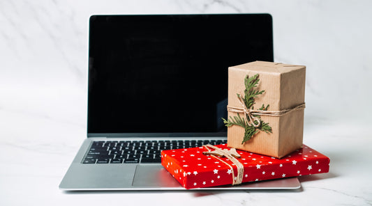 Weihnachtsgeschenke für Technikliebhaber vor einem Laptop