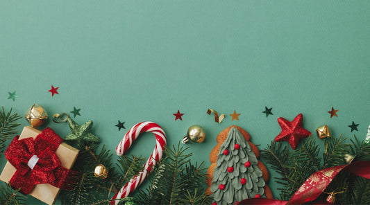 Weihnachtsgeschenke mit Zuckerstange, Tannenzweigen und Dekoration auf grünem Hintergrund